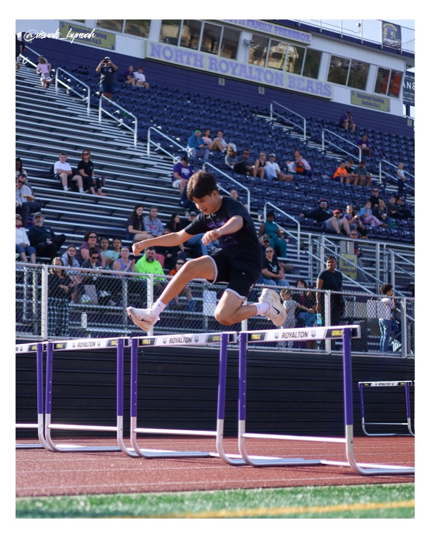 Track athlete clearing a hurdle