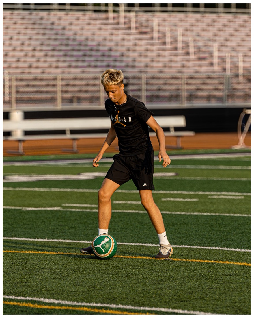 Soccer player controlling the ball at sunset